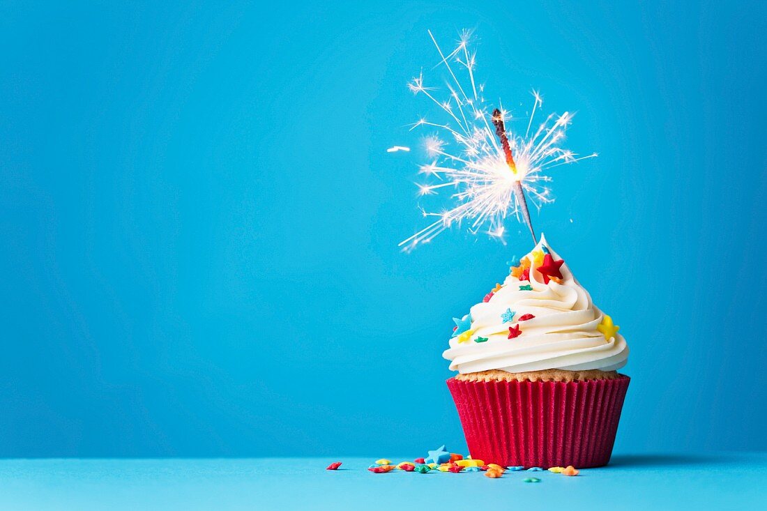 Cupcake with sparkler against a blue background