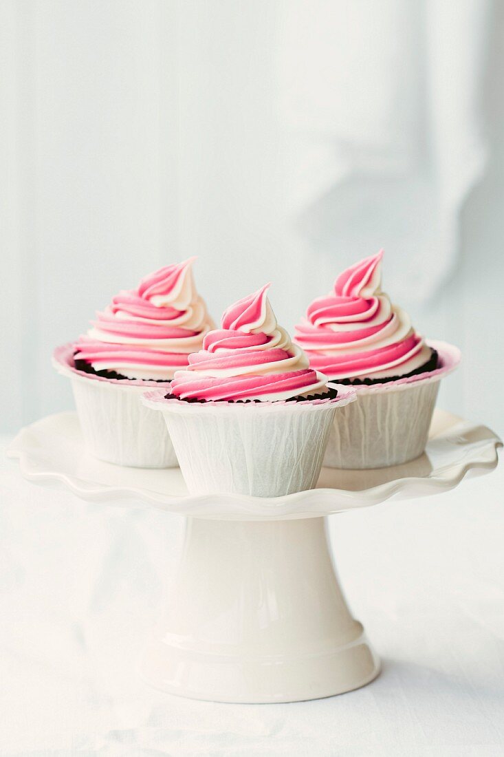 Cupcakes mit Himbeer-Swirl auf einem Kuchenständer
