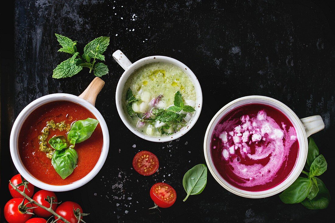 Verschiedene kalte vegetarische Suppen: Gurken-Gazpacho mit Minze, Rote-Bete-Suppe mit Feta, Tomatensuppe mit Pesto