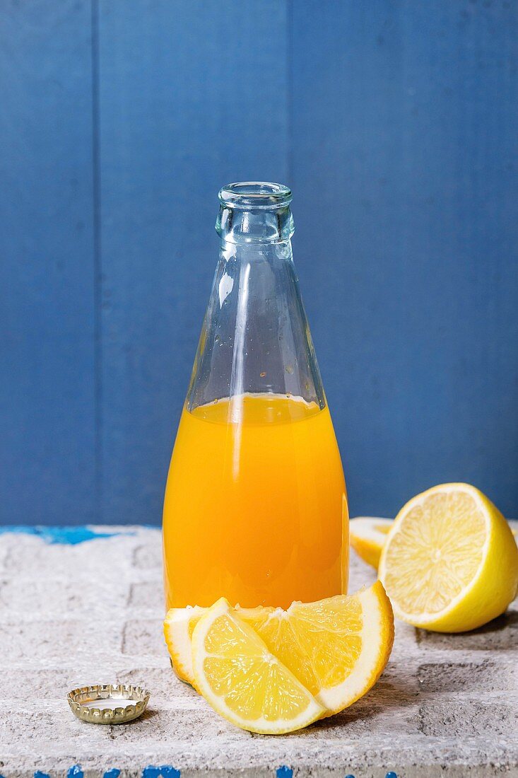 Geöffnete Glasflasche mit Orangen- Zitronen-Limonade