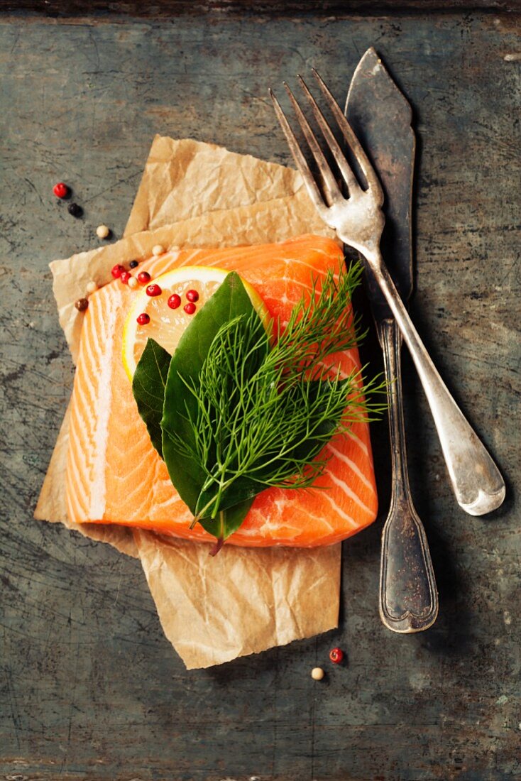 Raw salmon fillet and ingredients for cooking in a rustic style