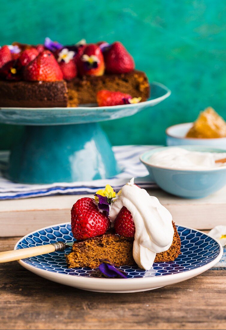 Honey cake with strawberries, cream and horned pansy