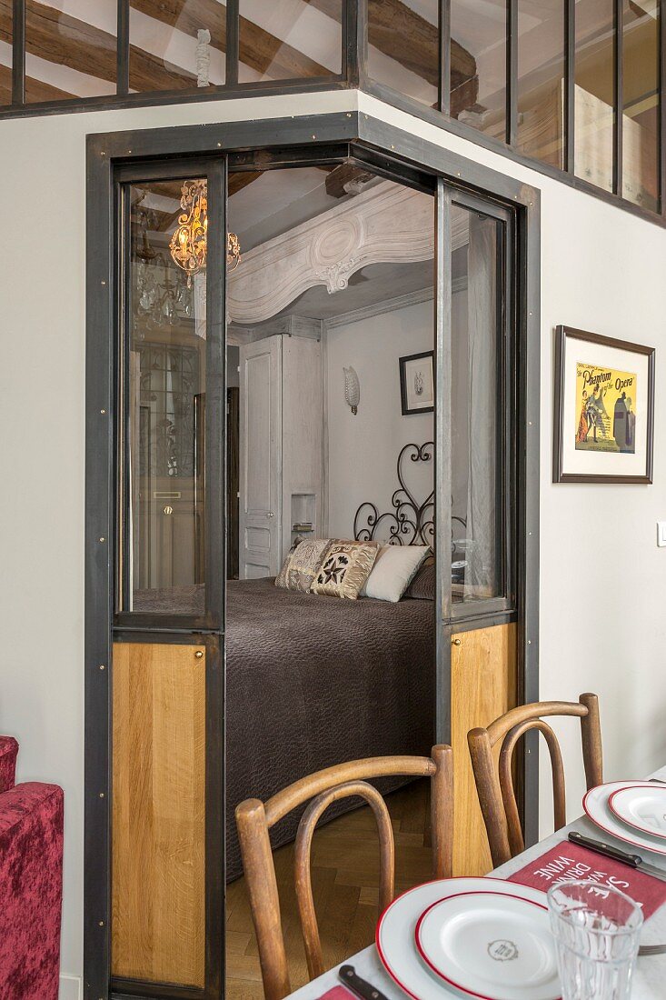 Open sliding doors with view into bedroom integrated into eclectic apartment