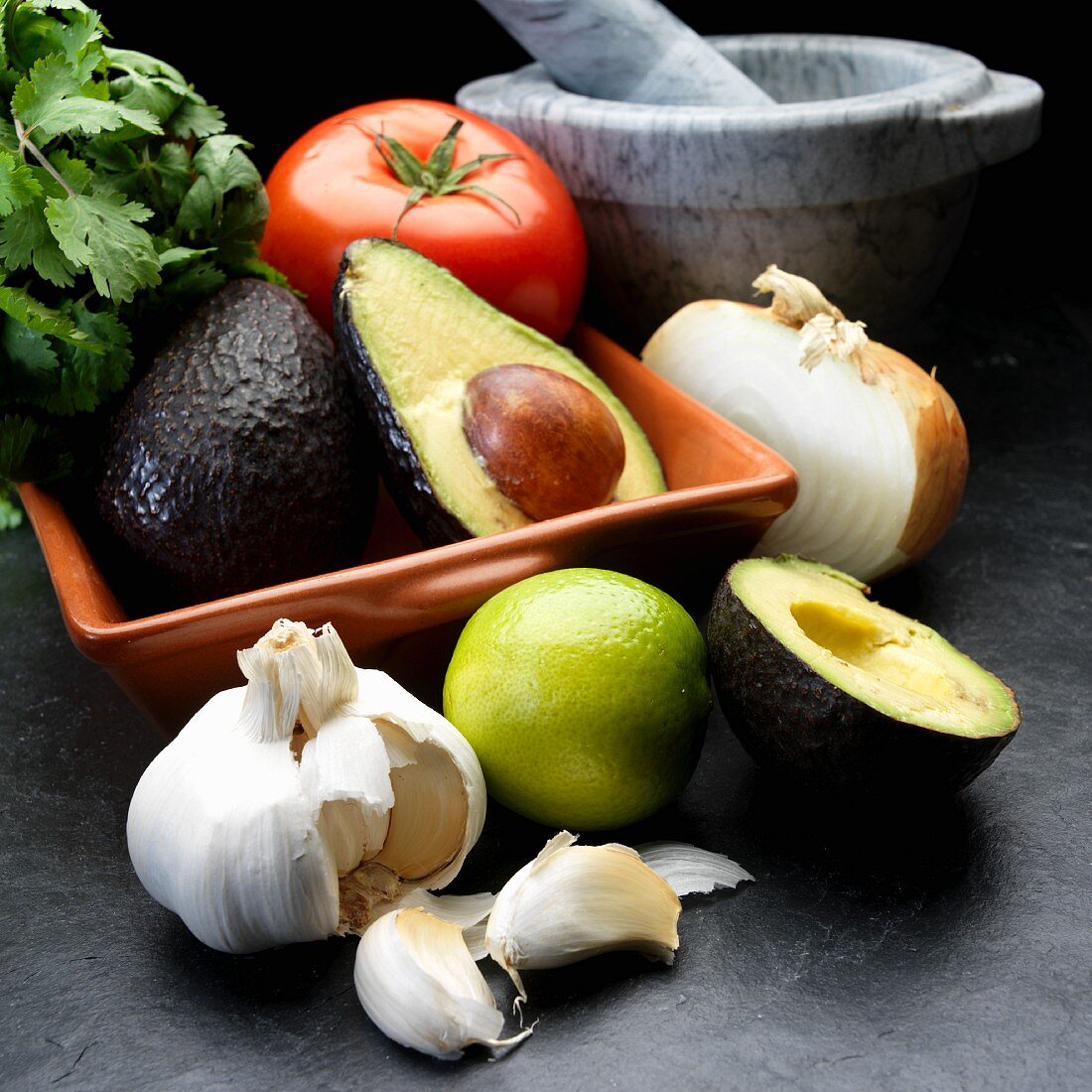 Zutaten für Guacamole: Avocado, Zwiebeln, Tomaten, Knoblauch, Koriander