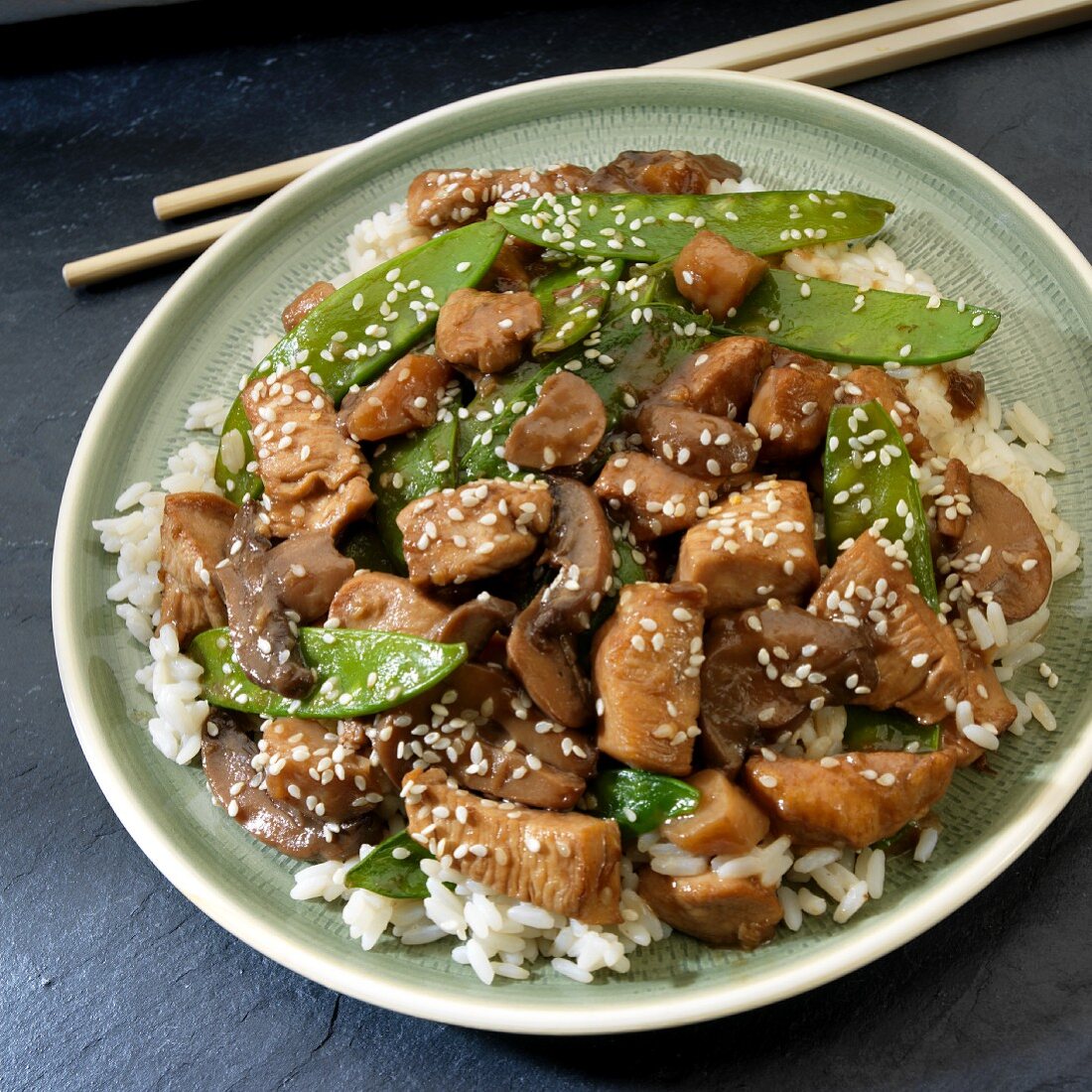 Stir-fried chicken with mangetout on a bed of rice (Asia)