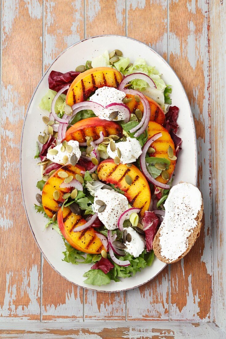 A salad with grilled peaches and goats' cheese, served with bread coated in goats' cheese
