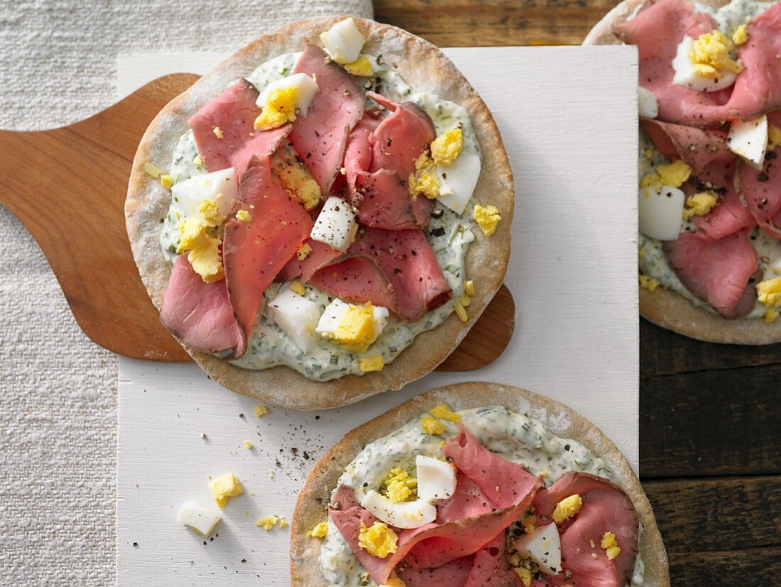 Pizza with roast beef, egg and mustard and herb cream