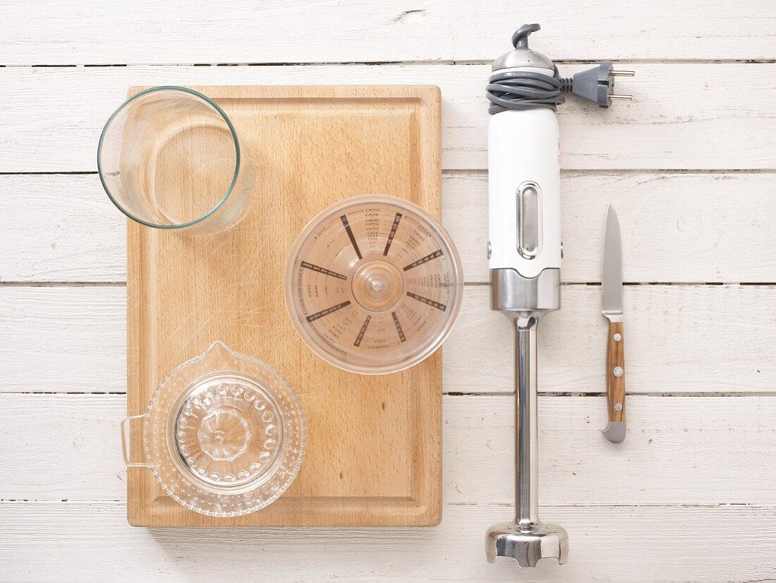 Kitchen utensils: a citrus press, measuring cup, hand blender and knife