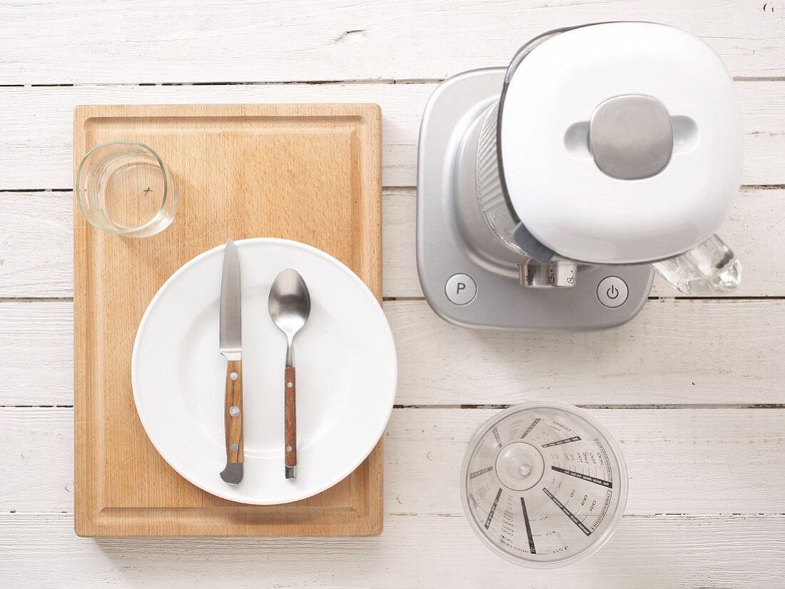 Kitchen utensils: a blender, measuring cup, cutlery and a plate