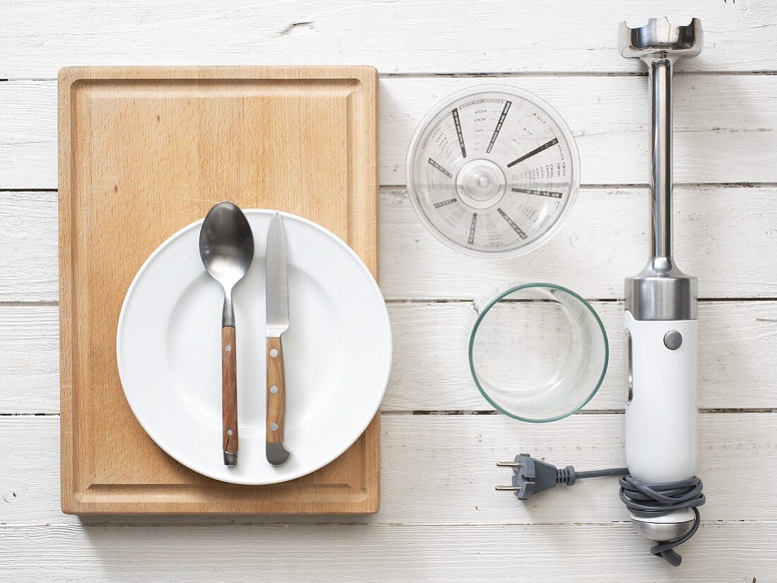 Kitvhen utensils: a hand blender, cutlery, measuring jug and glass