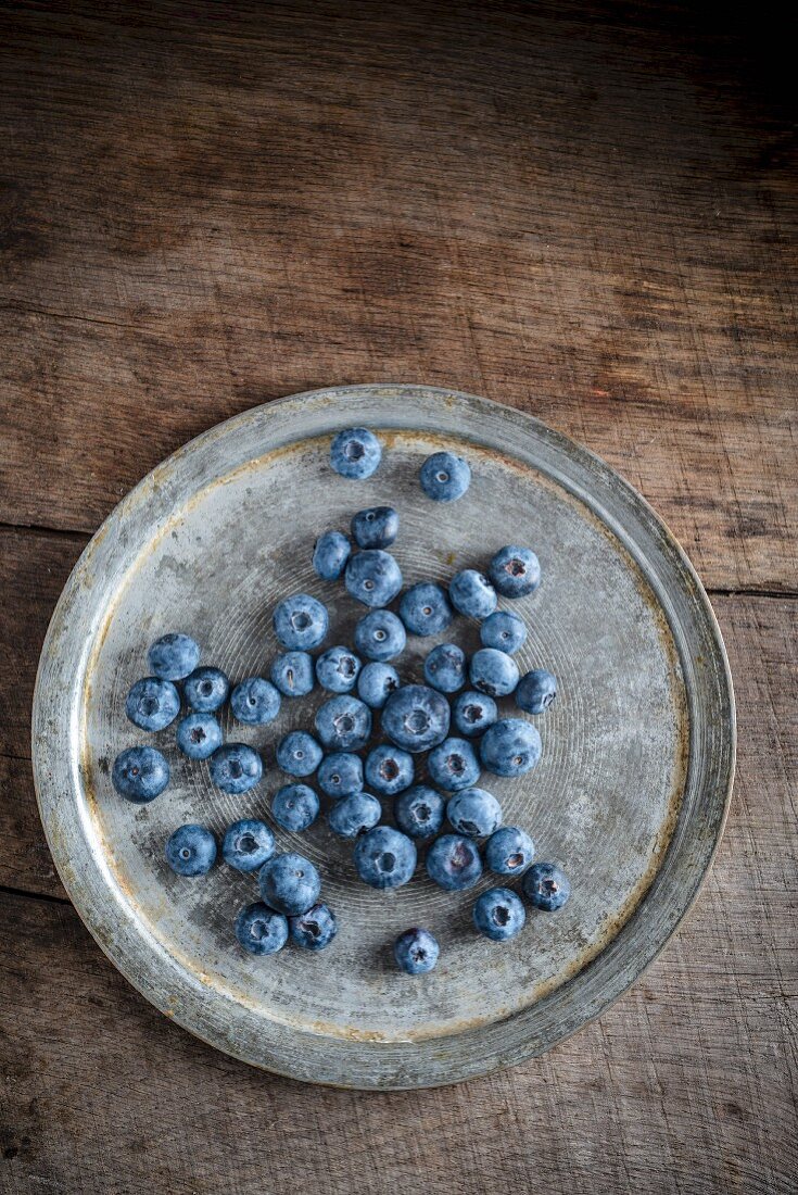 Blueberries on a metal plate (seen from above)