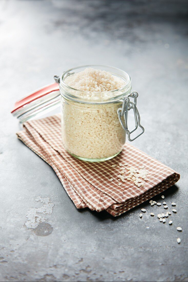 Short-grain rice for rice pudding in a preserving jar on a tea towel