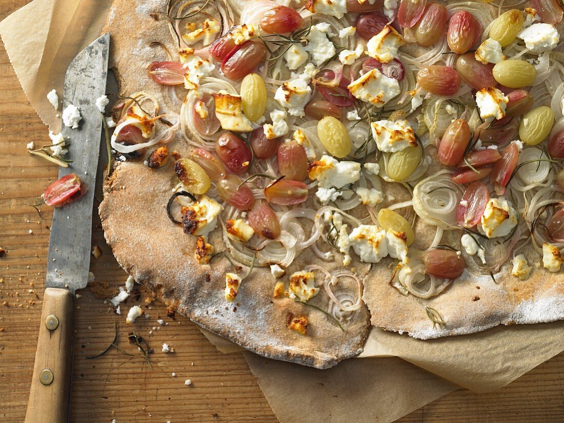 An onion flatbread with grapes, sheep's cheese and rosemary