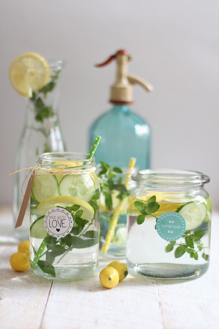 Water aromatised with cucumber, lemon and herbs in glass jars