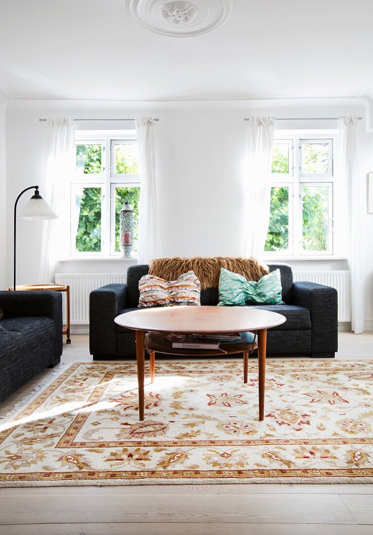 Round coffee table and black sofa in bright living room