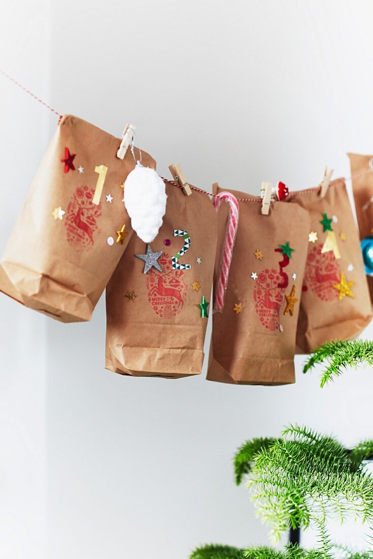 DIY-Adventskalender aus dekorierten Papiertüten an Wäscheleine