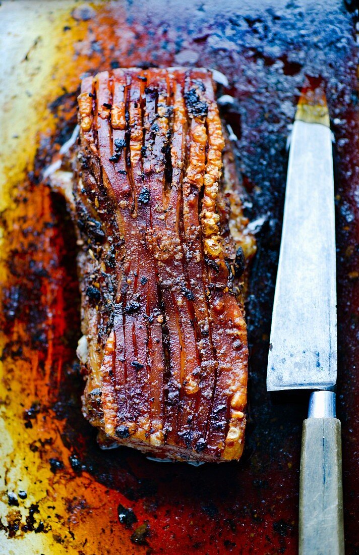 Slow-roasted pork belly with chilli and fennel in a roasting tin with meat juice (Italy)