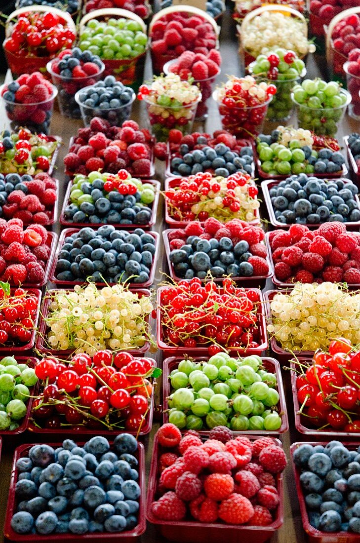 A market stand with fresh berries in cardboard punnets