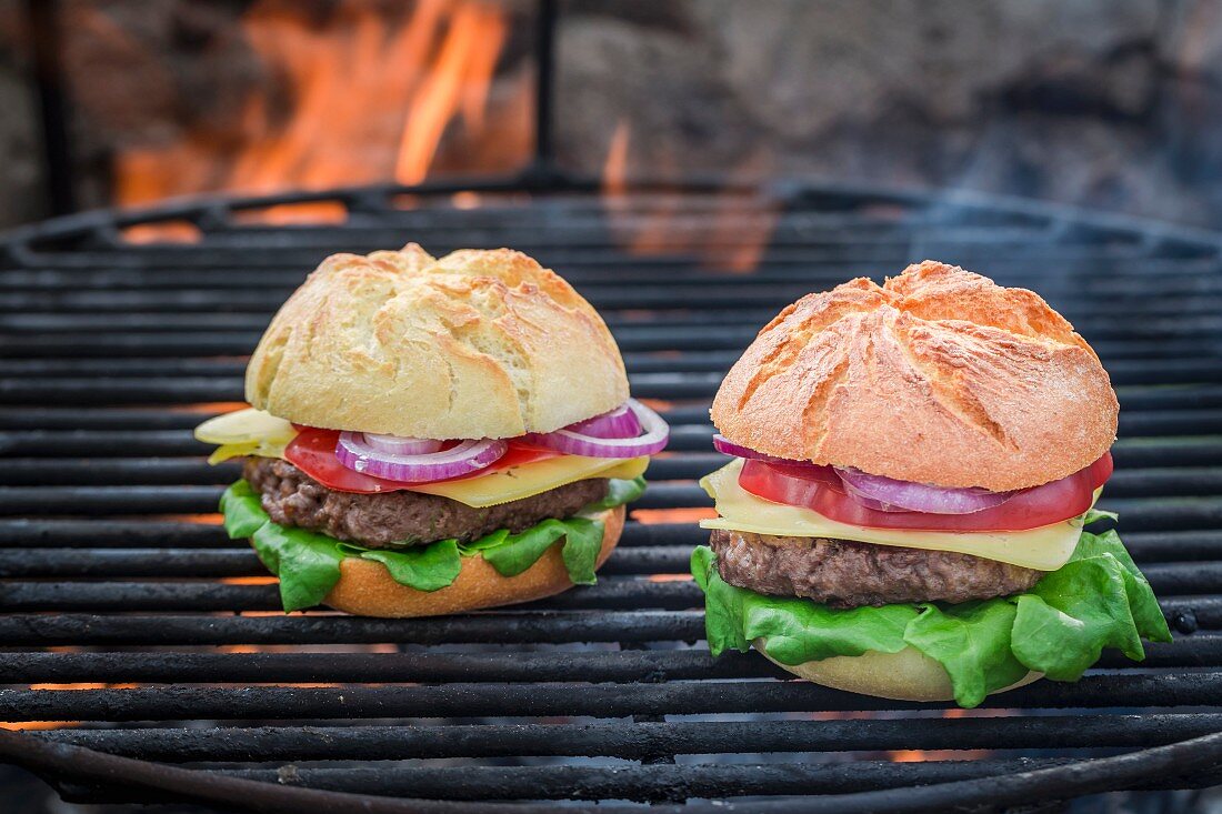 Zwei hausgemachte Hamburger auf dem Grill mit Feuer