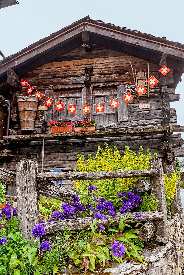 A mountain hut with Swiss flags in Valais, Switzerland