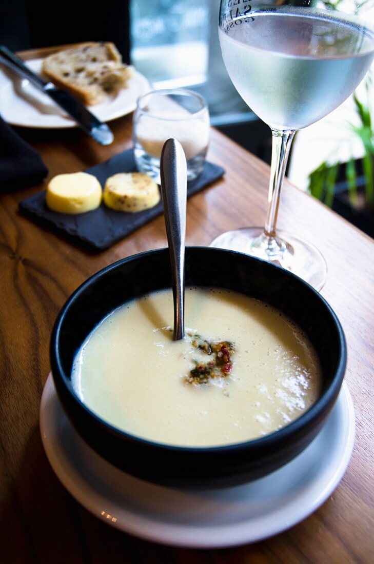 Cauliflower soup with aubergine South restaurant table with bread, butter and ice-cold water