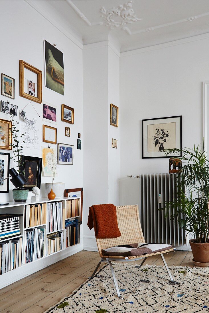 Reading corner and gallery of pictures in period apartment with stucco ceiling