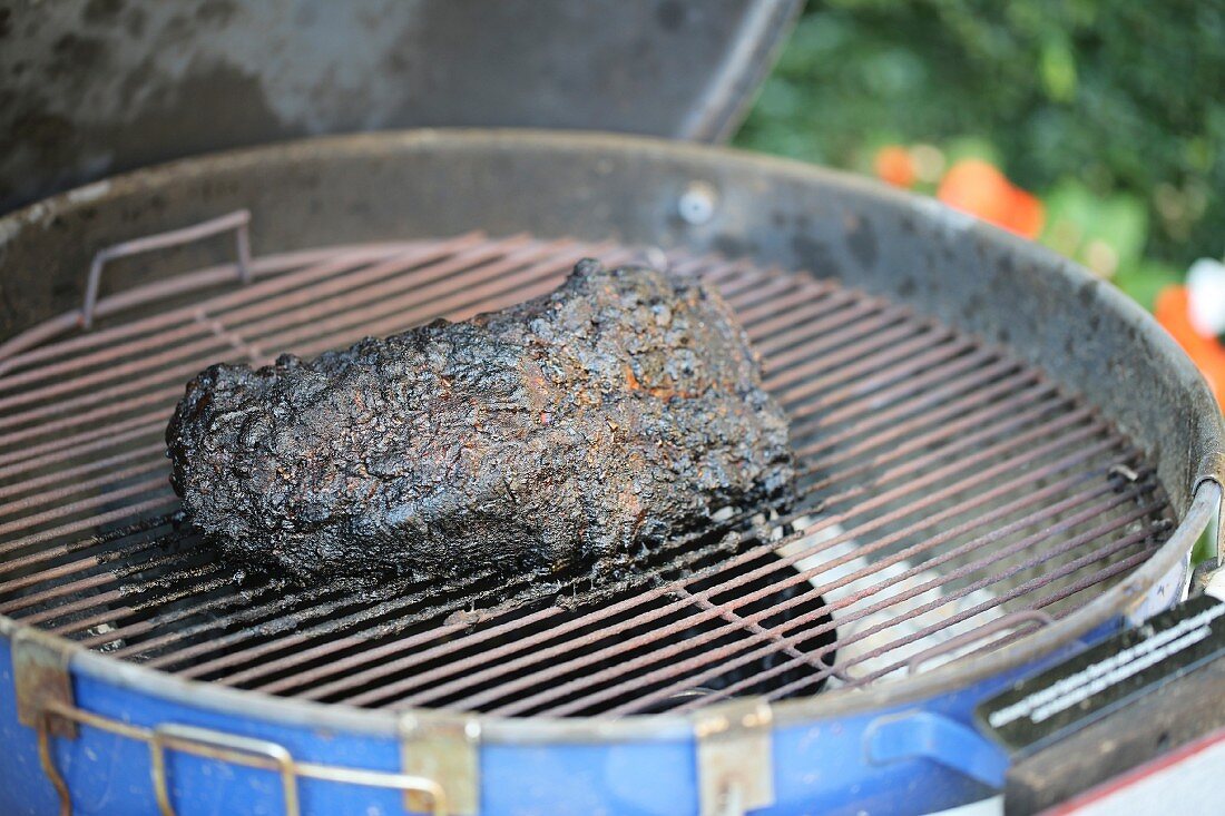 BBQ Pulled Pork am Stück mit schwarzer Kruste auf dem Grill