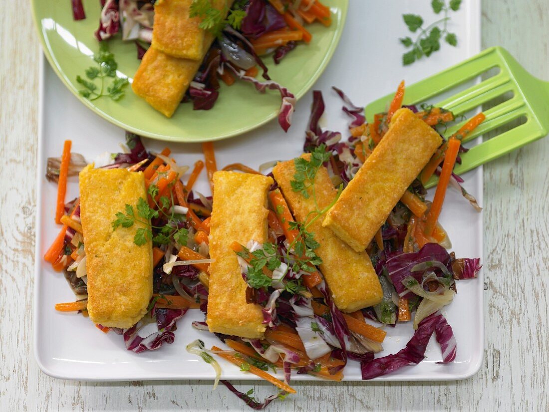 Fried polenta strips on a bed of carrot and radicchio