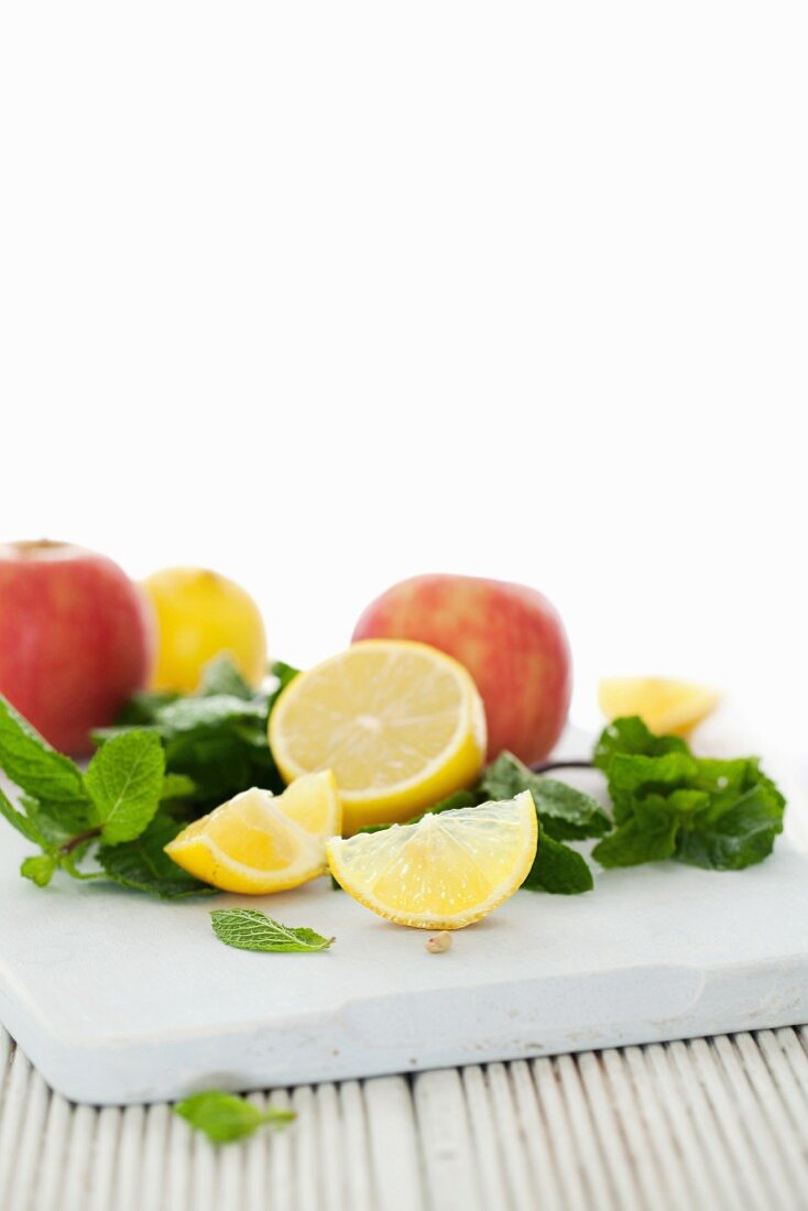Apples, lemon and mint on a chopping board