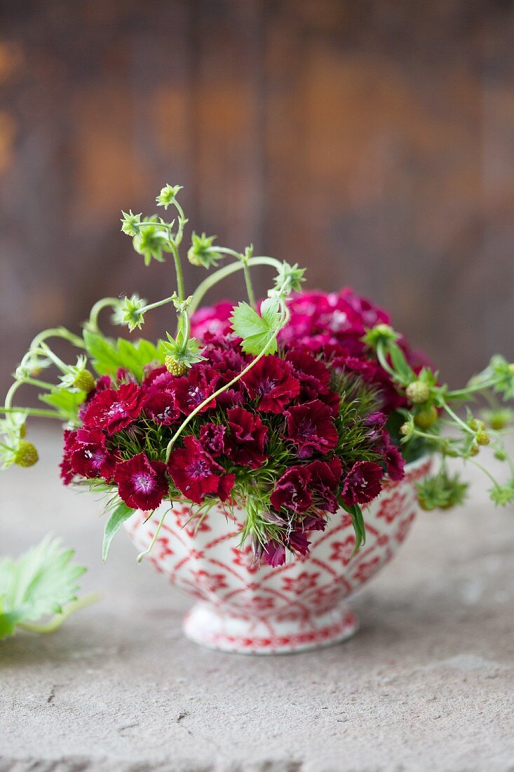 A bowl with Sweet William flowers and strawberries