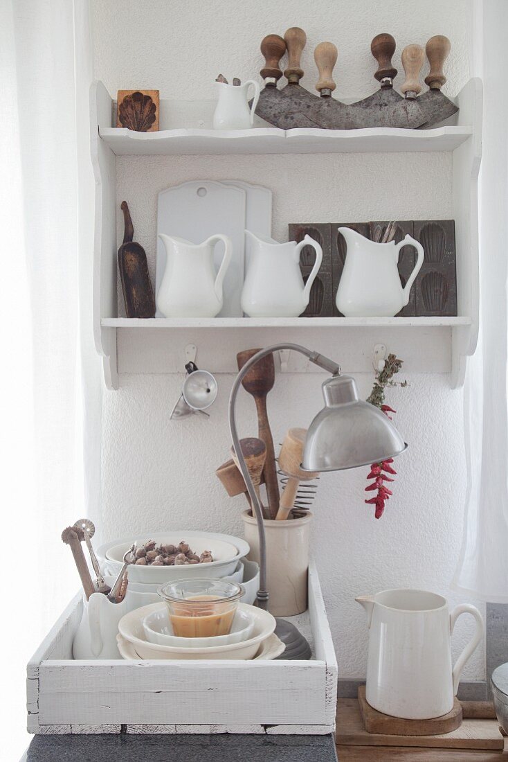 Old kitchen utensils on old wall-mounted shelves and on wooden tray