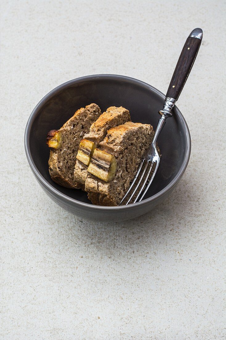 Drei Scheiben glutenfreies Bananenbrot mit Chiasamen in Schälchen