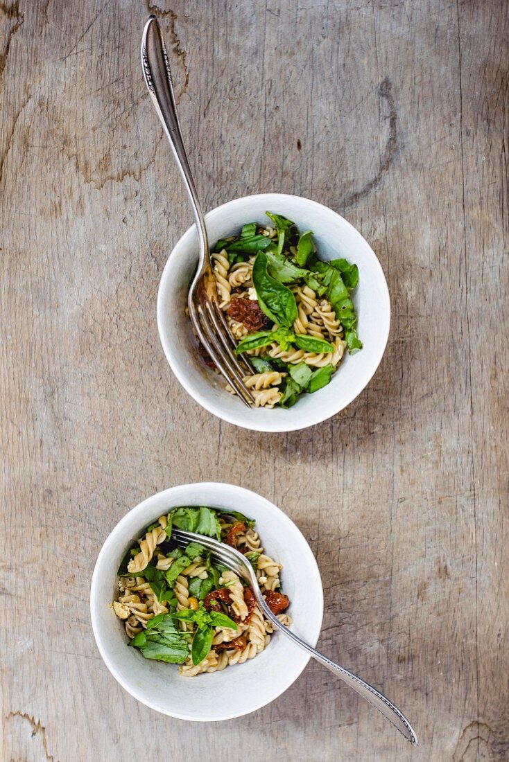 Pasta salad with basil and dried tomatoes (seen from above)