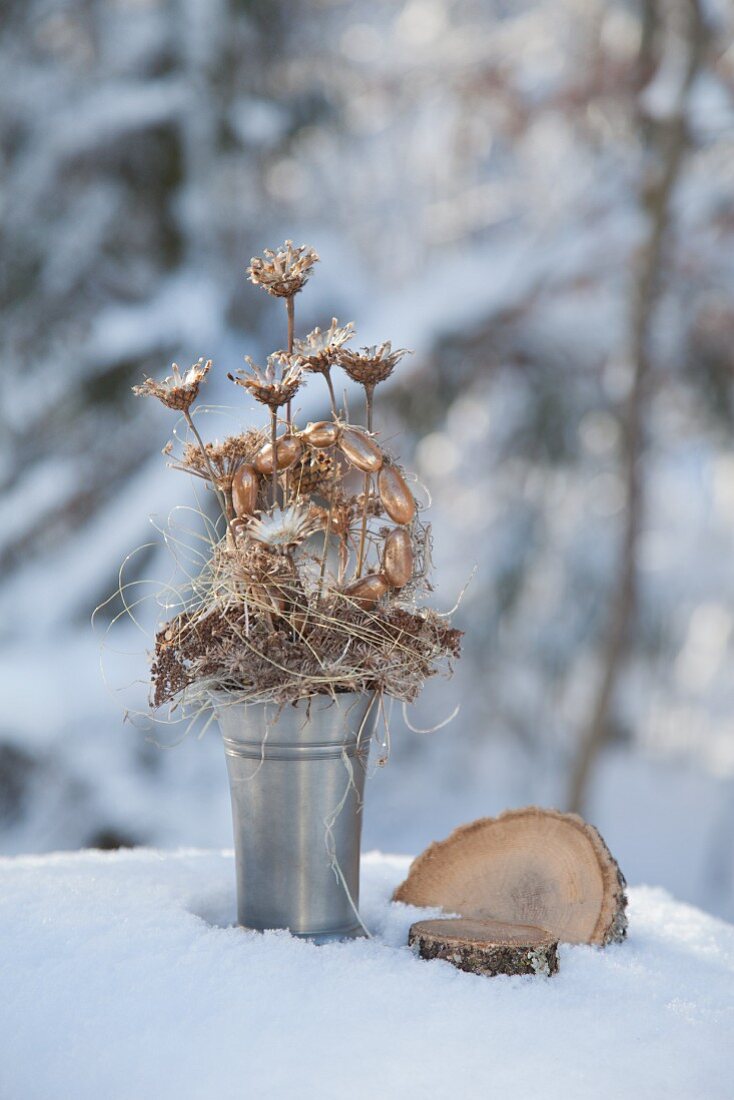 Shiny gold arrangement of dried flowers in pewter trophy