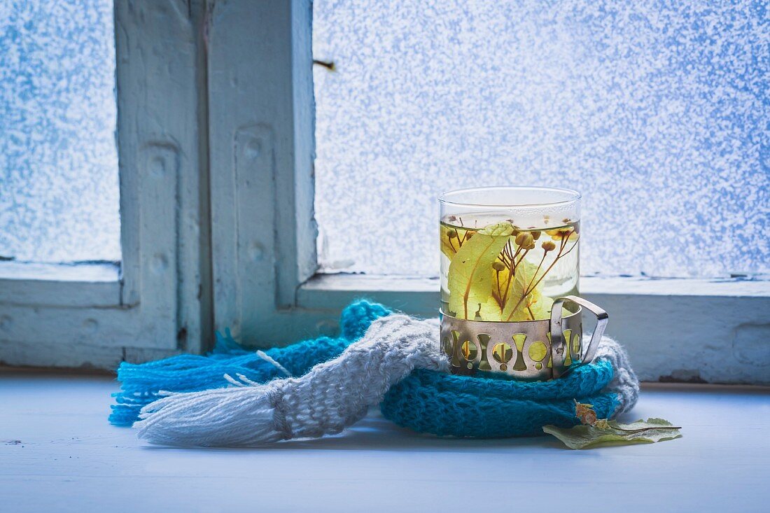 Hot tea with herbs by a window