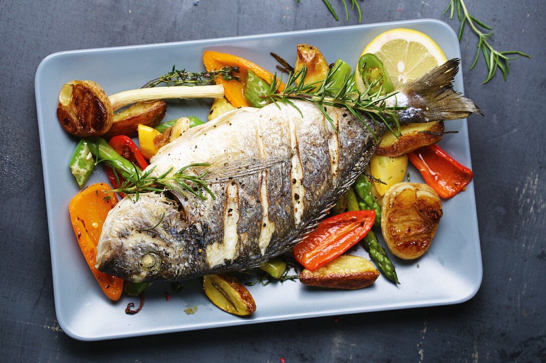 Gilt-head bream with rosemary on a bed of oven-roasted vegetables