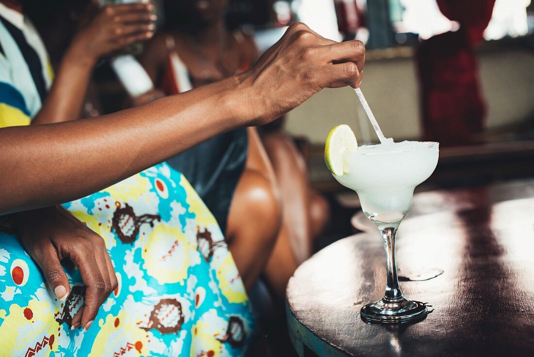 Dark-skinned people with a cocktail at the Potato Shed restaurant (Johannesburg, South Africa)