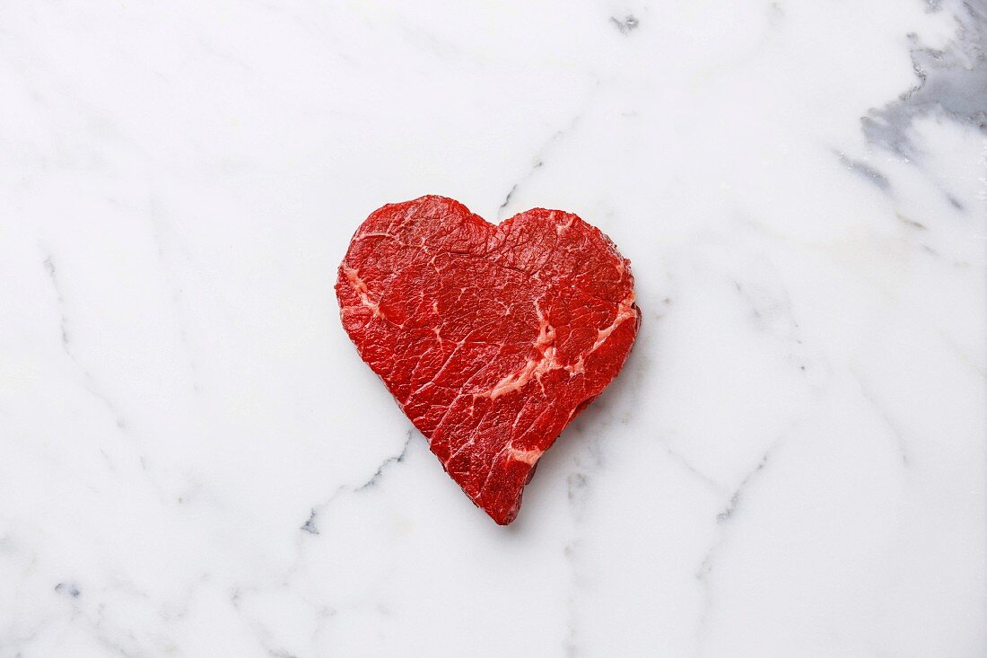 Frisches Rindfleisch in Herzform auf Marmor Hintergrund