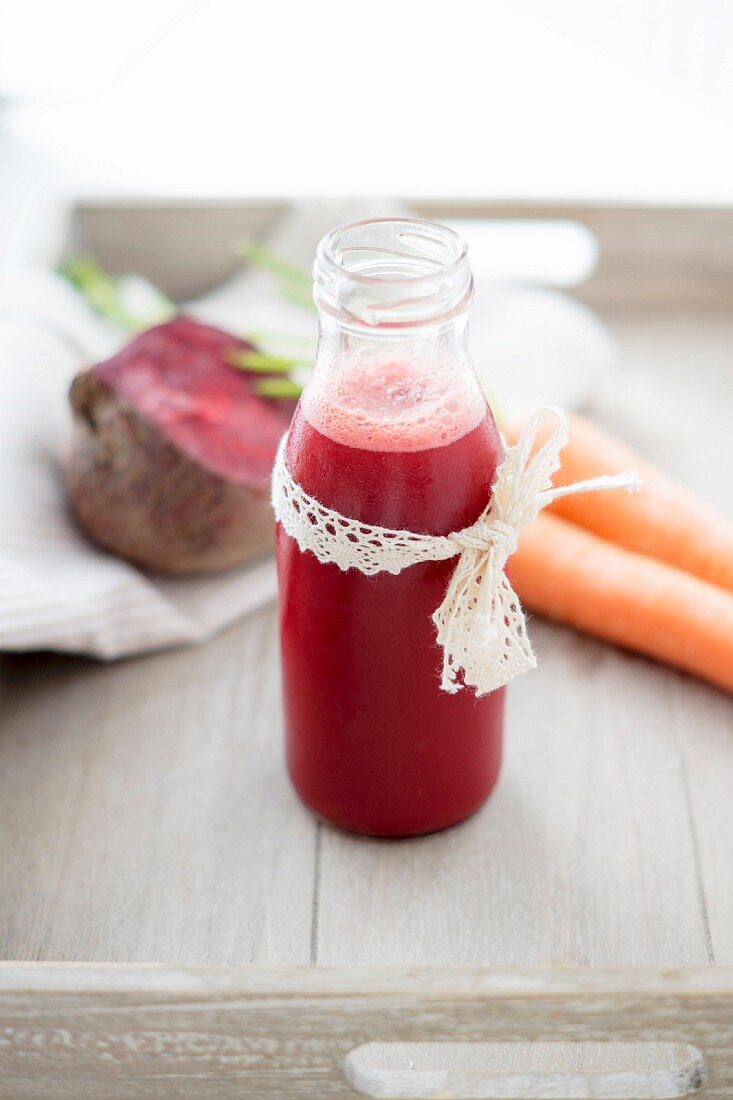 Rote-Bete-Karotten-Saft und frisches Gemüse auf Tablett