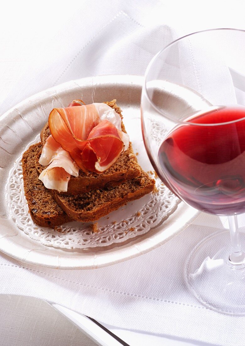 Kastanienbrot mit Rohschinken und Glas Rotwein