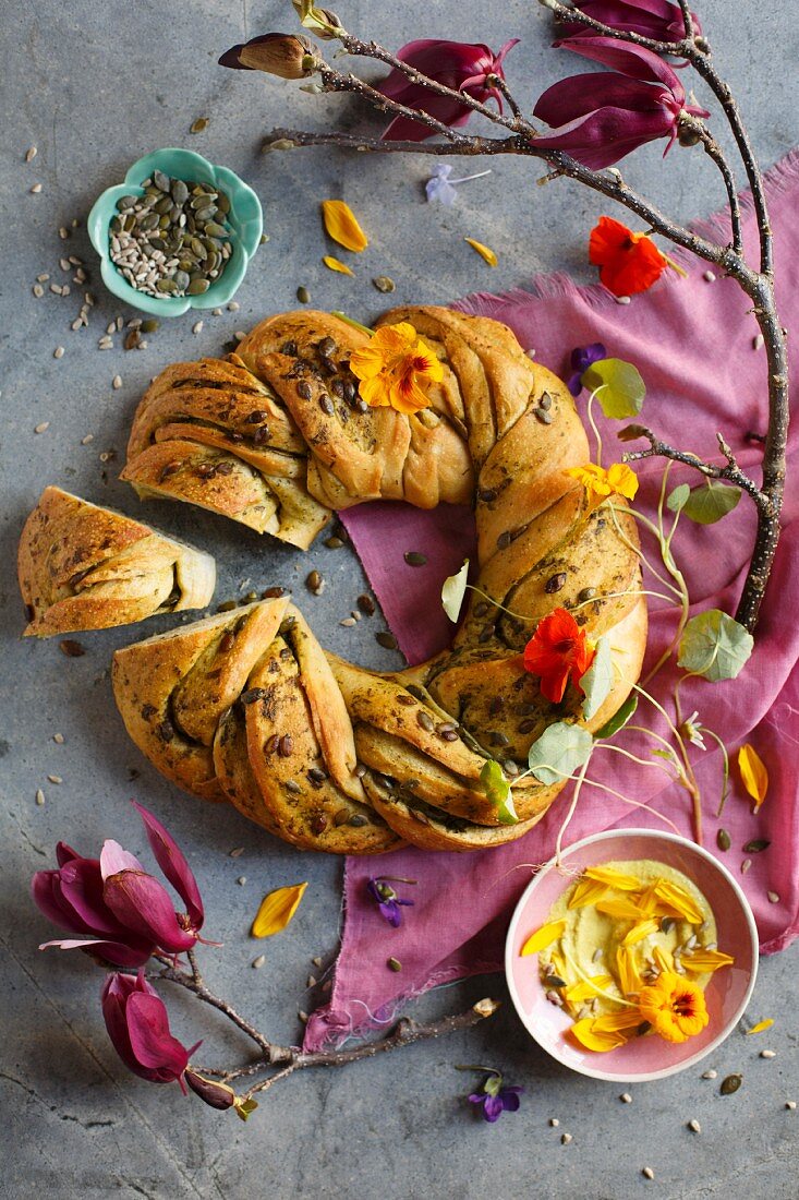 A bread ring with pumpkin seeds and nasturtium flowers