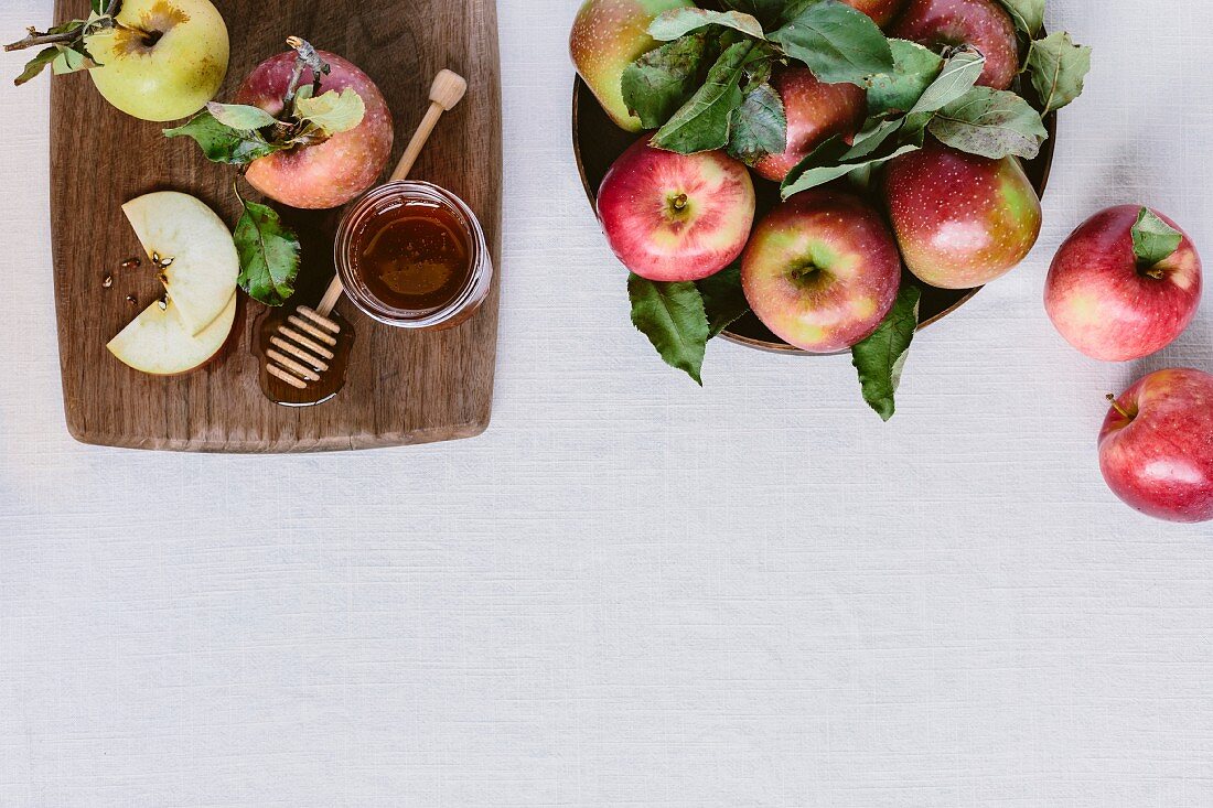 Freshly picked apples and honey on a white backdrop