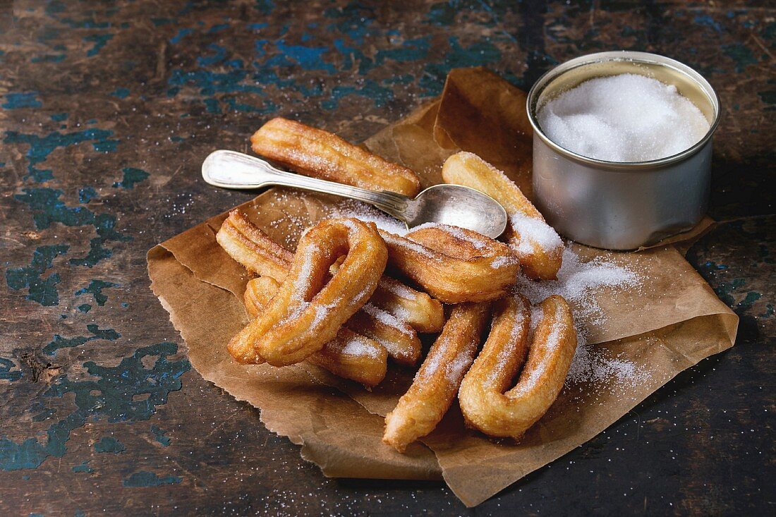 Spanish churros with granulated sugar on baking paper