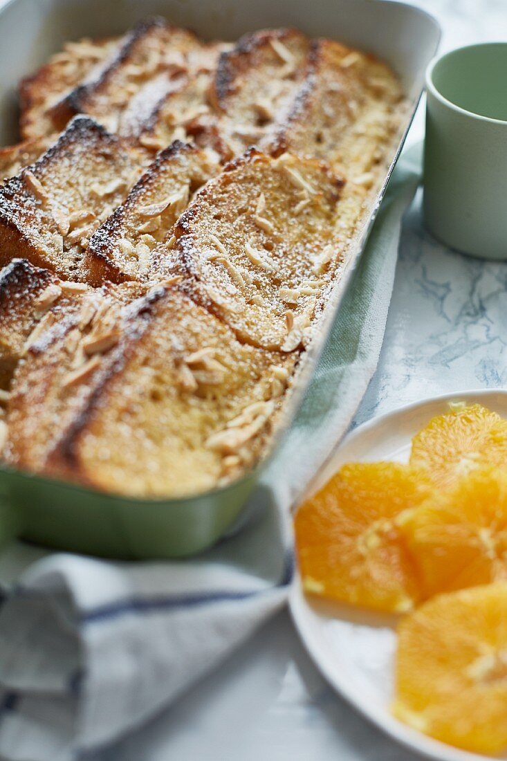Baked French toast with slivered almonds and orange slices