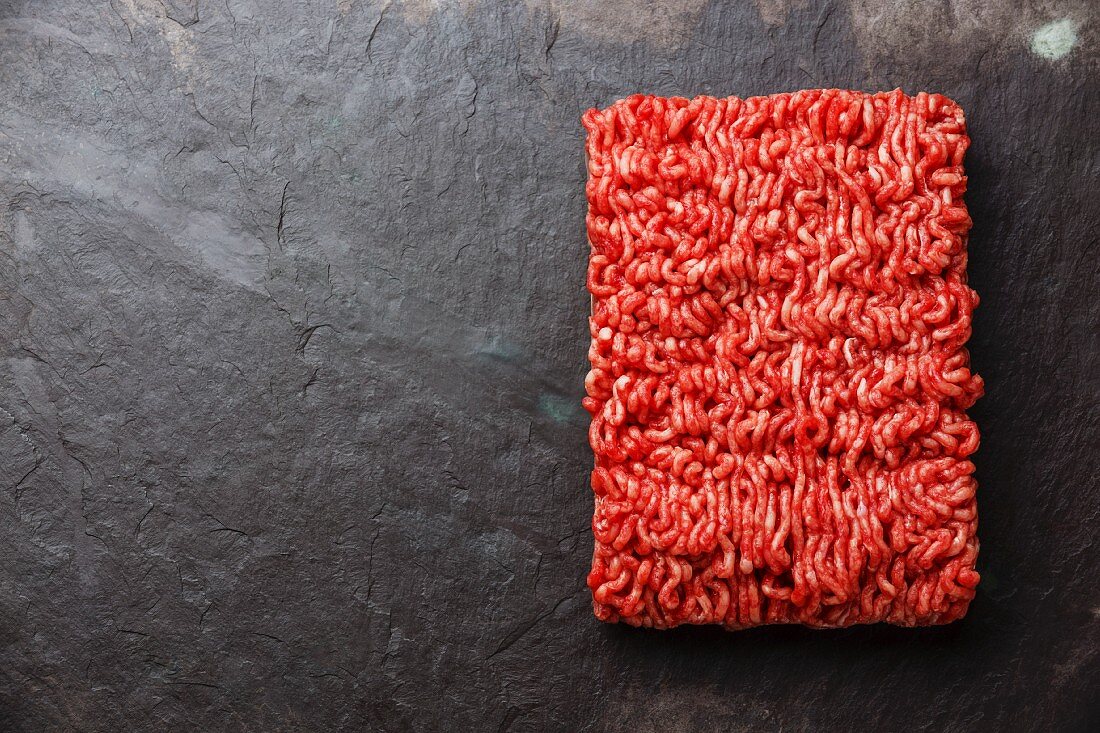 Fresh minced beef in a rectangle on a stone surface