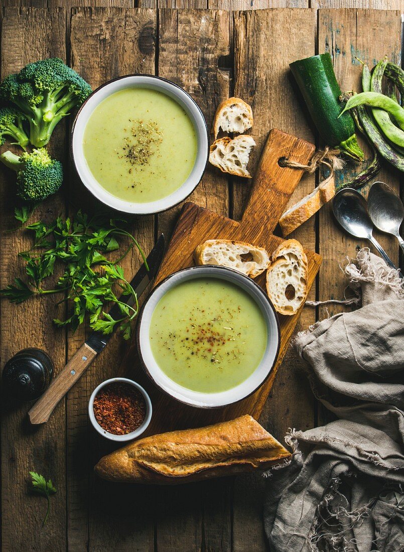 Gemüsecremesuppe mit Erbsen, Brokkoli und Zucchini, serviert mit Baguette