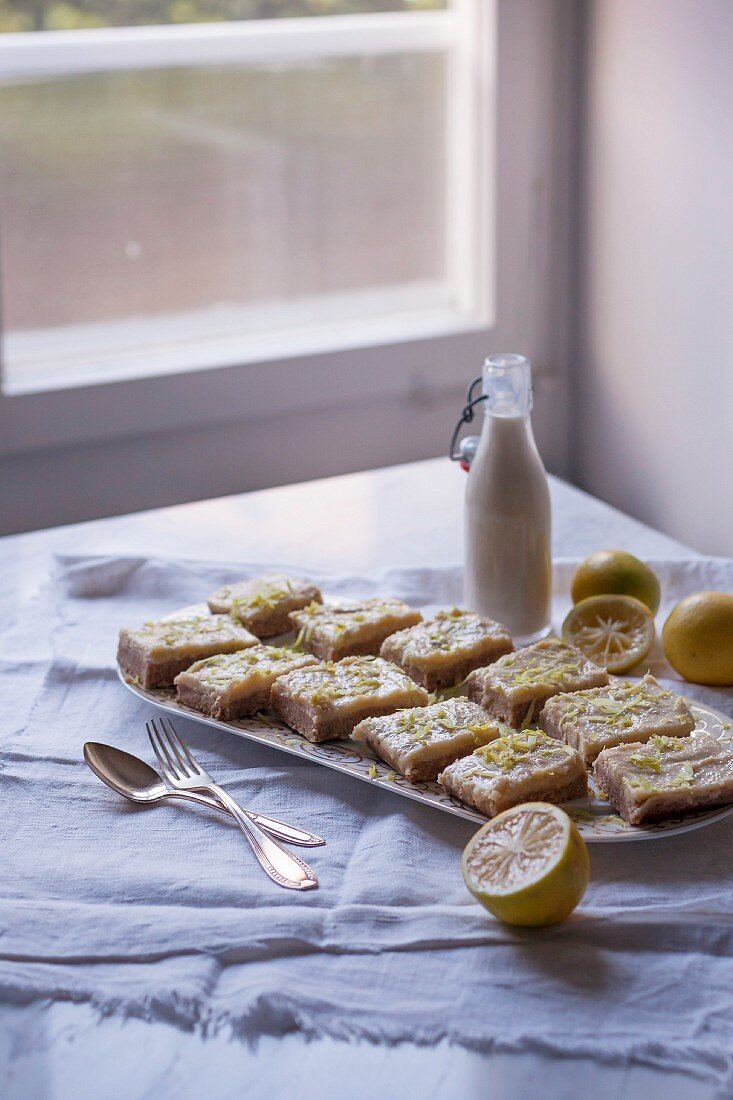 Coconut and lemon slices (unbaked) with lemon zest on a platter