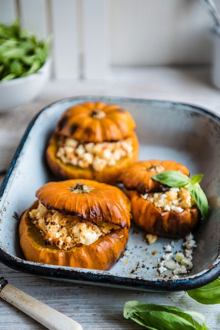 Pumpkins stuffed with couscous and feta, garnished with basil