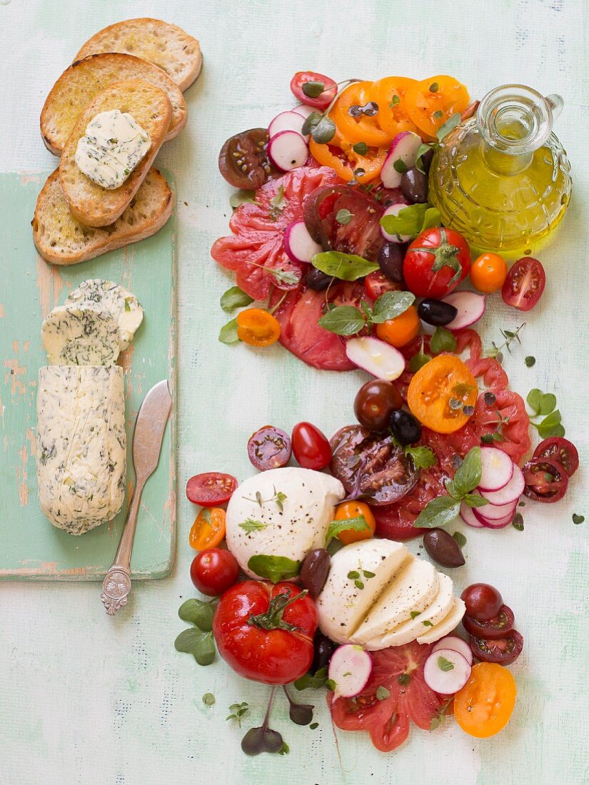 Tomaten-Mozzarella-Salat mit Radieschen, Kräutern, Olivenöl, Knoblauch-Kräuter-Butter und Brot