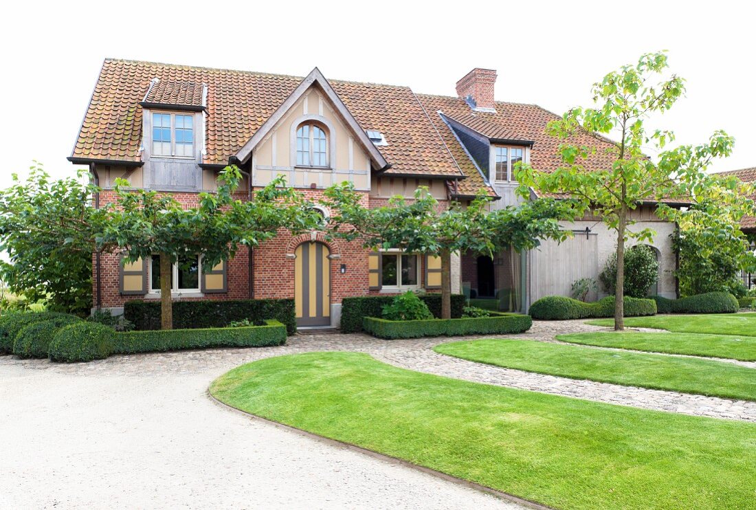 Modern topiary and lawns outside country house